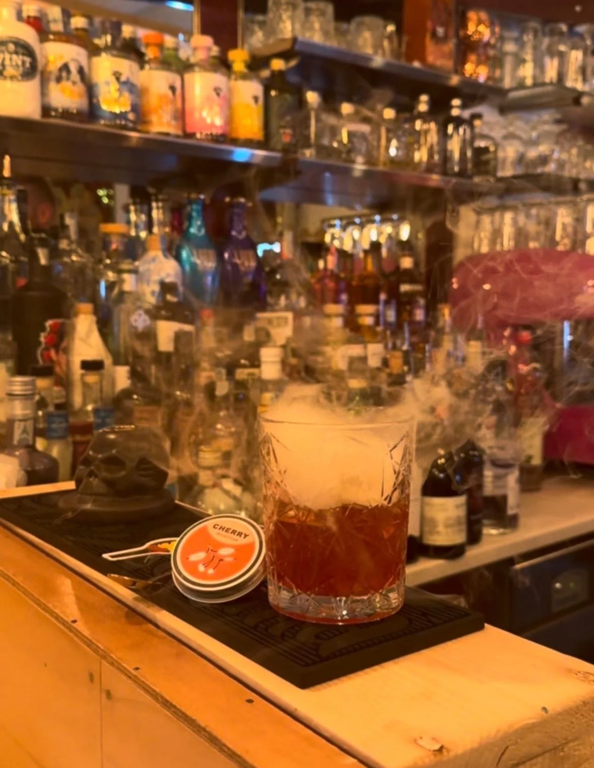 Cocktail affumicato alla ciliegia servito sul bancone