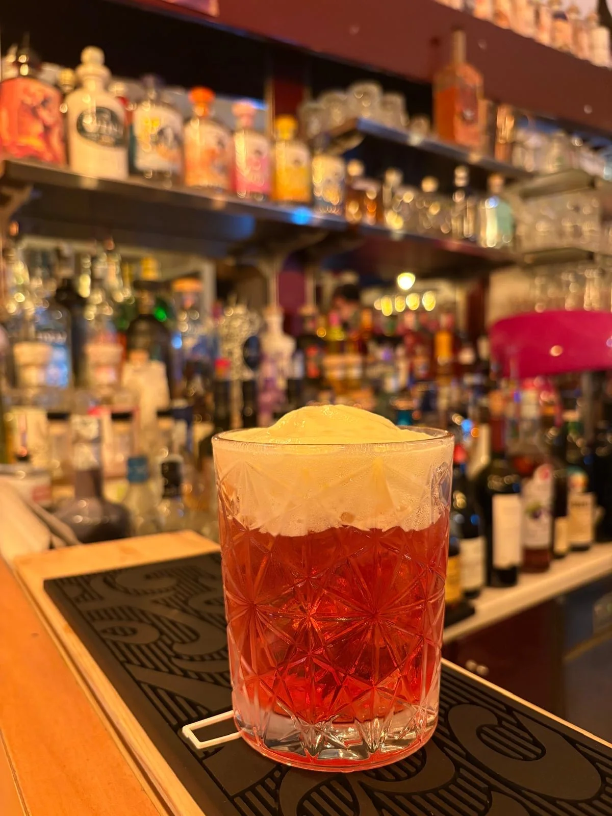 Cocktail rosso con schiuma servito al bancone Cocktail rosso con schiuma servito al bancone